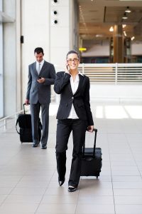 businesspeople walking in airport with luggage